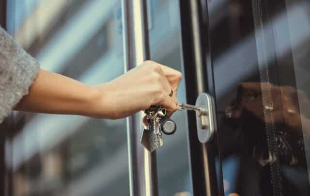 Woman Unlocking a Glass Door