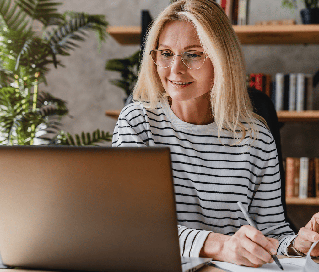 Woman in front of laptop looking pleased