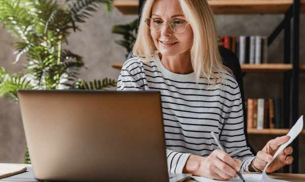Woman in front of laptop looking pleased